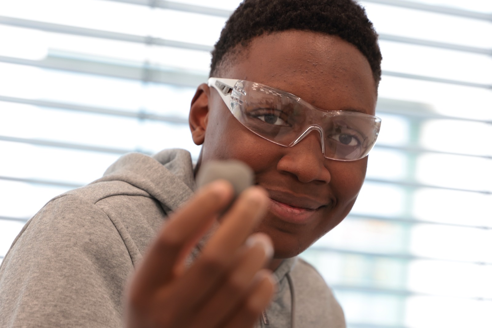 Ein Jugendlicher entdeckt mit Schutzbrille eine neue berufliche Tätigkeit